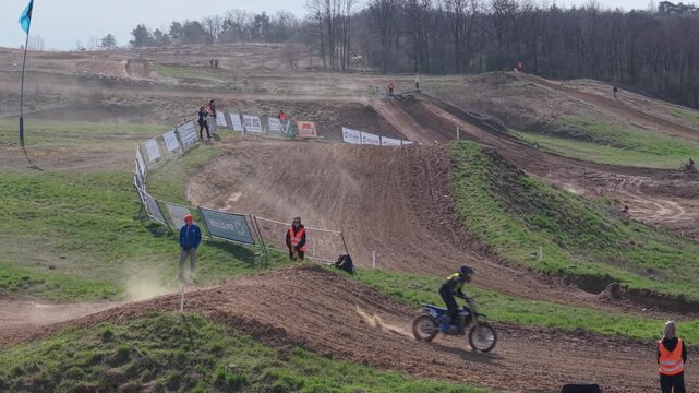 Aerial drone footage of motocross cross country race, dirt bikes speeding on rugged track, riders competing in off-road extreme motorsport event, dynamic action and dust clouds