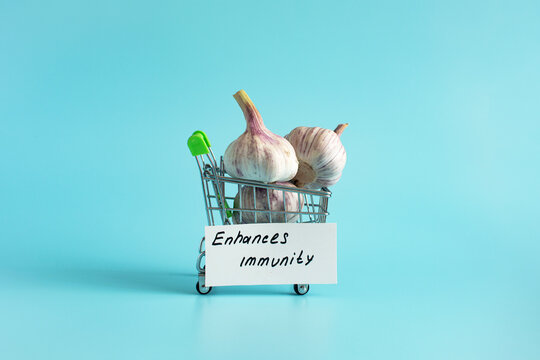 Garlic is a natural antiseptic and medicinal product. Garlic bulbs in close-up on a light background and an inscription on paper.