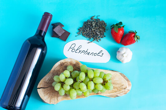 Products containing useful substances and polyphenols in their composition. Grapes, garlic, chocolate, green tea, nuts, strawberries in close-up on a light background and the inscription on paper "pol