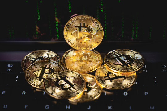 Un tas de pi&egrave;ces bitcoin devant un fond de code vert, symbolisant la technologie blockchain, la cybers&eacute;curit&eacute; et l&rsquo;univers des cryptomonnaies.