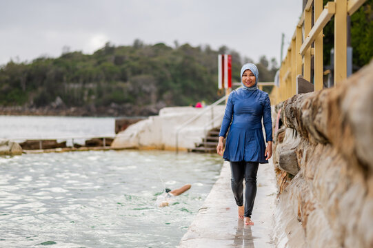 Filipina woman wearing a burkini walking on the ocean poolside