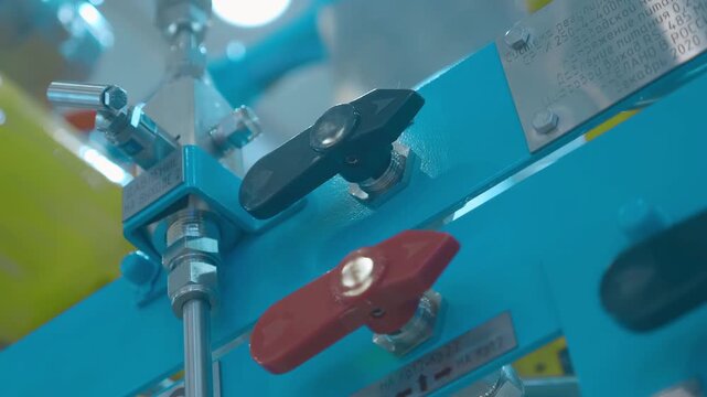 Black and red switches for liquid fraction flow direction on oil refining industrial equipment. Closeup. Shot in motion