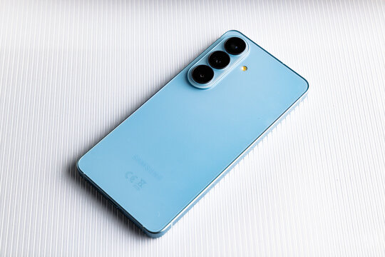Back view of blue Samsung Galaxy S24 smartphone with triple camera