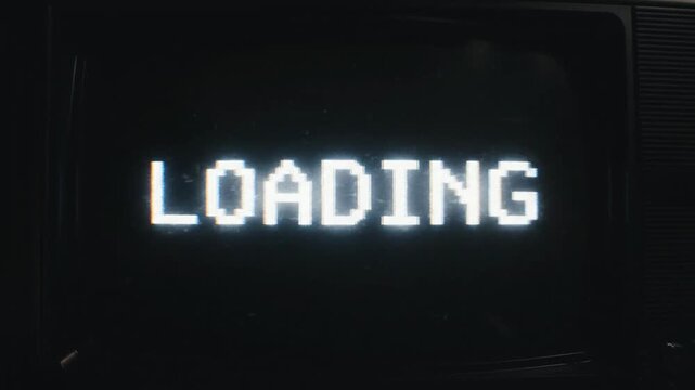 Medium shot. loading 8 bit retro screen on vintage CRT monitor in dark room. Analog static, glitch, scanlines, flickering light. Technology, gaming, retro.