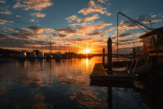 Yamba Marina sunset with sailboats and calm water reflecting the sky