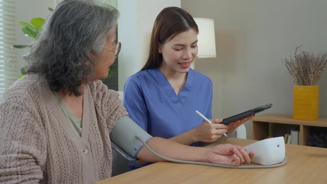 Caregiver elderly care home nurse supports senior patient health with blood pressure monitor and tablet, gentle visit at home with trust and dignity, vital signs check recorded for safety and support