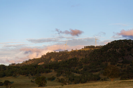 Dusk sky with wind turbines on rural hilltop ridgeline in Australia