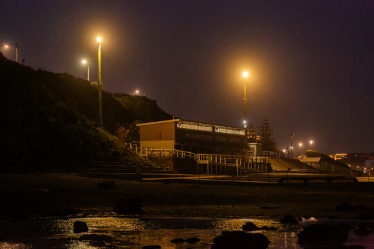 Merewether Ocean Baths building on coast at night