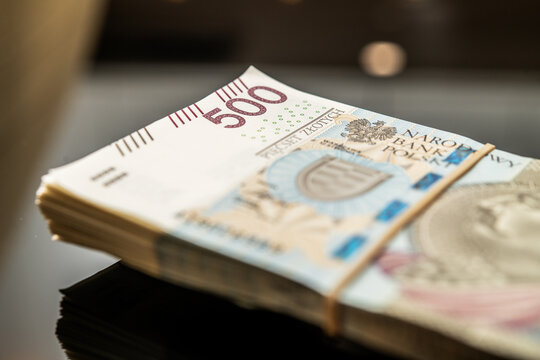 Polish Money 500 złoty banknotes stack on reflective surface with VAT tax currency inflation