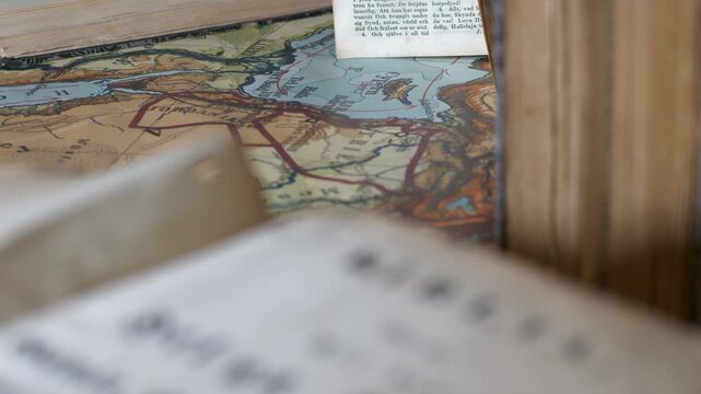 Rack focus from antique swedish bible title page to vintage map of middle east in old book