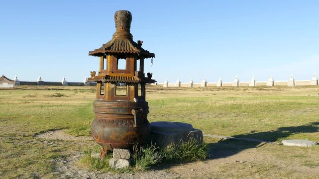 Huge copper incense burner on the background of the walls of an ancient Buddhist monastery Erdene Zuu, Kharkhorin, Mongolia. Stupas - Buddhist sacred architecture, the walls. Solar summer day.