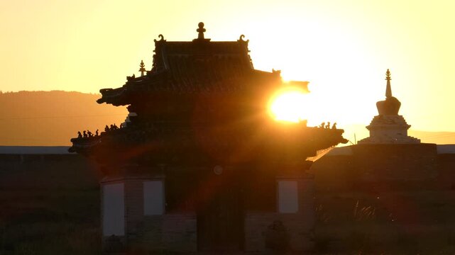 Small temple and a stupa of an ancient Buddhist monastery in the background of the setting sun. Erdene Zuu Monastery. Kharkhorin, Mongolia 