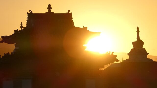 Small temple and a stupa of an ancient Buddhist monastery in the background of the setting sun. Erdene Zuu Monastery. Kharkhorin, Mongolia 
