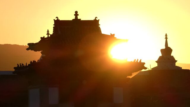 Small temple and a stupa of an ancient Buddhist monastery in the background of the setting sun. Erdene Zuu Monastery. Kharkhorin, Mongolia 