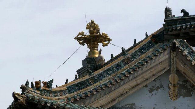 Decoration of the roof of the Mongolian temple in the form of a sacred Buddhist symbol on the background of the blue clear sky. Mongolia, Erdene Zuu monastery.