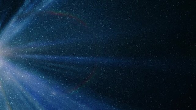 Colored rays emerge from the edge of the frame and move on a black background. The projector operates in a smoky space. Spectacular lens flares decorate the picture. View through sparkling particles