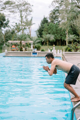Naklejka premium Southeast Asian man about to jump into pool