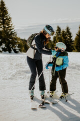 Obraz premium Teaching kids the joy of skiing on a bright winter day in the mountains