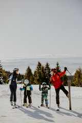 Obraz premium Family enjoys skiing on a snowy mountain during daytime in winter