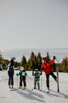 Family enjoys skiing on a snowy mountain during daytime in winter