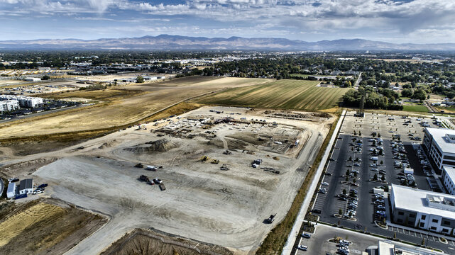 Aerial View of Active Commercial Construction Site with Parking and Heavy Equipment