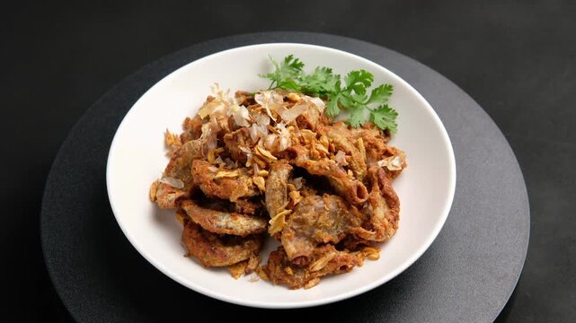 Deep Fried Pork Intestines with Crispy Garlic in white plate.with chilli sauce.