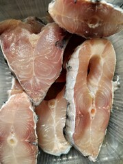 Raw chopped Catla fish pieces, fresh uncooked cleaned Asian freshwater fish in the carp family Cyprinidae display in close view. © SubhamayAcharyya