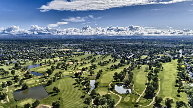 Aerial View of Lush Green Golf Course with Multiple Water Hazards and Dramatic Sky