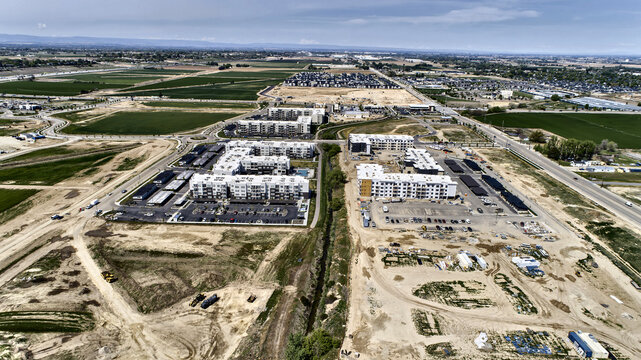 Aerial View of Large New Apartment Complex Under Construction Adjacent to Agricultural Farmland