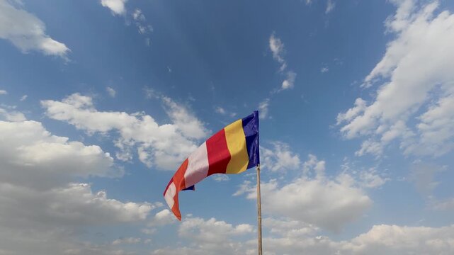 Waving colorful Buddhist Flag in cloudy blue sky background 4k video.