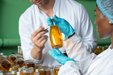 Quality control inspection of bottled fruit juice by nutritionists at a beverage factory.