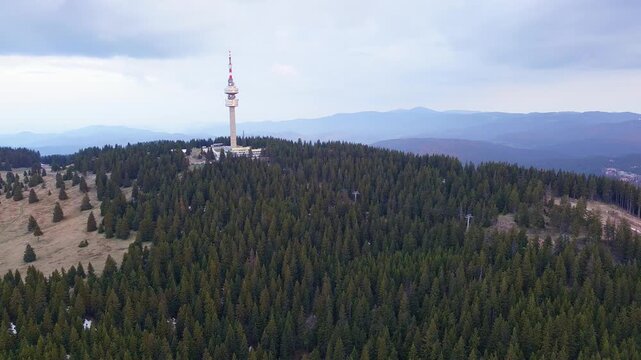 Tower Snezhana on peak of Snezhana covered with spruce forests in Rhodope mountains