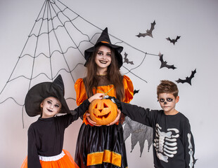 Fototapeta premium Kids in Halloween costumes with pumpkin.