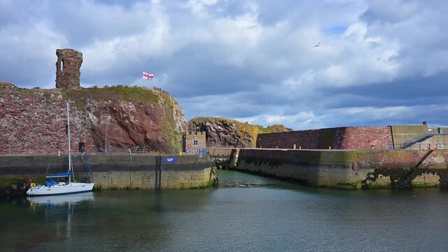 Ein Hafen mit einem alten Turm und ruhigem Wasser unter bew&ouml;lktem Himmel, Dunbar, East Lothian, Schottland, Vereinigtes K&ouml;nigreich, Gro&szlig;britannien