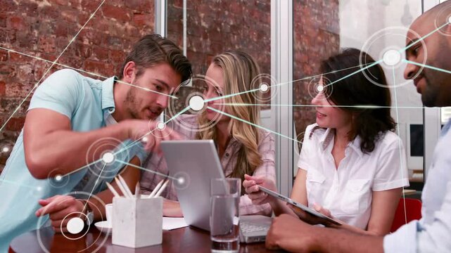 Pointing man guiding team studying growing node web in office with tablet, in business attire