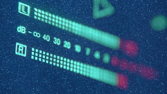 The level indicator of а music from professional recorder is glows blue and shows the decibel range and overload area with high accuracy. View through sparkling particles. Closeup. Macro