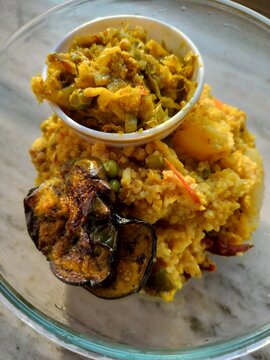 Indian Freshly made hot Khichdi or khichri is a dish in South Asian cuisine made of rice and lentils with numerous variations. mung dal khichri food served with vegetable.