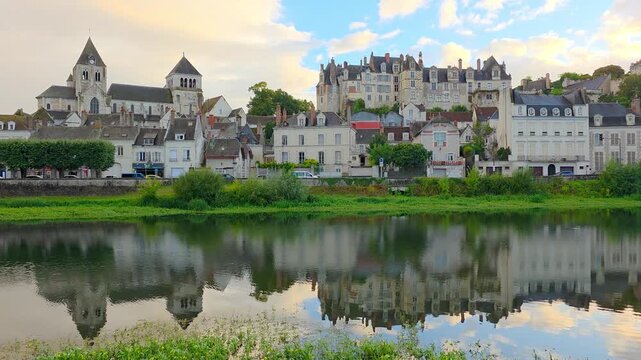 Evening in the Loire Valley of France. Slow panning motion. Cathedral, chateau and bridge in Saint Aignan with reflections in the Cher River at sunset.