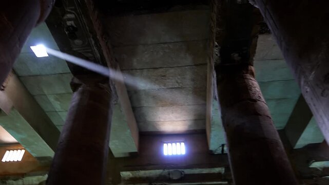 Sunlight streaming through the ancient halls of the Abydos Temple highlights detailed hieroglyphs and sacred architecture. Egypt.