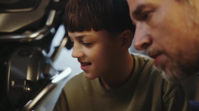 A father and son share time in a garage, focusing on fixing a motorcycle. They talk and laugh as they check tools and parts, enjoying the hands-on experience.