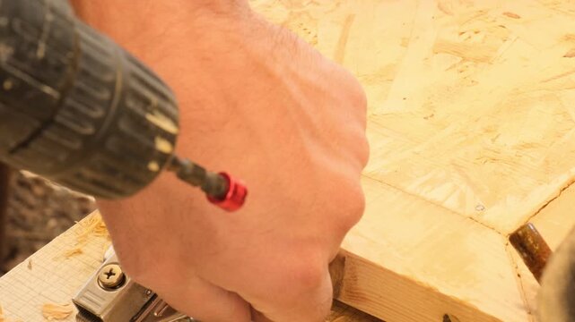 During screw installation, drill head slips. Unsuccessful attempt to fasten screw into wooden cabinet door for hinge attachment. Unpleasant situation in furniture production.