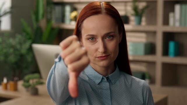 Dissatisfied sad Caucasian business woman showing thumb down in office negative result female businesswoman dislike gesture manager employer entrepreneur girl bad feedback deny failure problem indoor