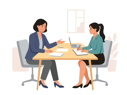 Two women in a business meeting discussing documents at a table.