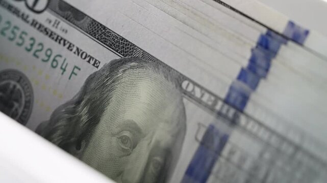 High speed currency counter device processing USD hundred dollar bills stack. Electronic banking equipment handling cash money financial audit. Wealth growth business investment accounting concept.