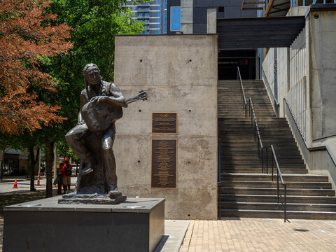 Metal Statue of Willie Nelson Holding Guitar With Monument Plaque in Downtown Austin, Texas
