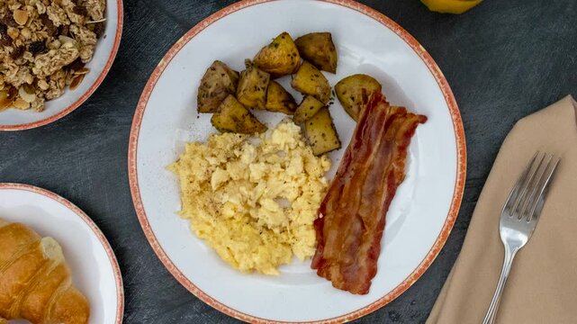A Rotating Plate of Scrambled Eggs with Bacon and Hash Brown Potatoes