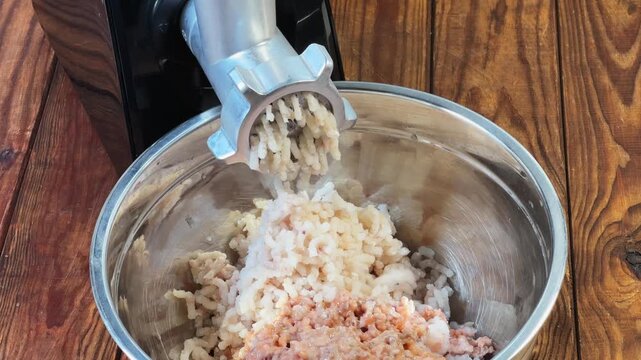 Grinding cod meat into ground fish with electric meat grinder