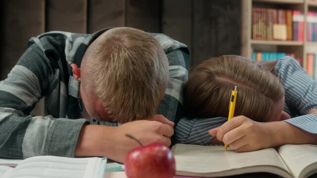 Exhausted Caucasian four teenage students sleeping table indoors school library tired classmates napping books one boy three girls pupils falling asleep after studying boring education fatigue indoor