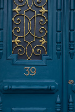 Close up of an ornate teal door with gold number 39