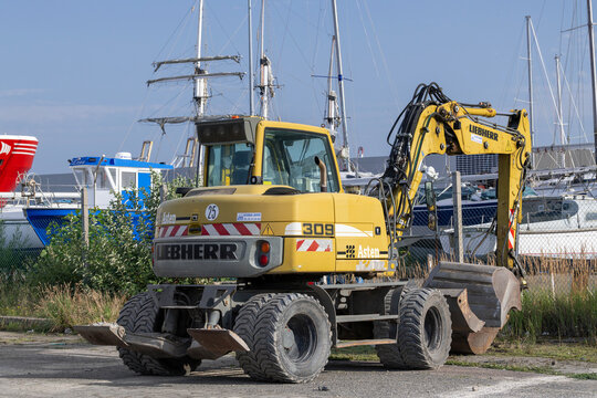 Le Havre, France - August 12th 2021 : View on a yellow wheeled excavator Liebherr A 309 Litronic for earthworks on a construction site.